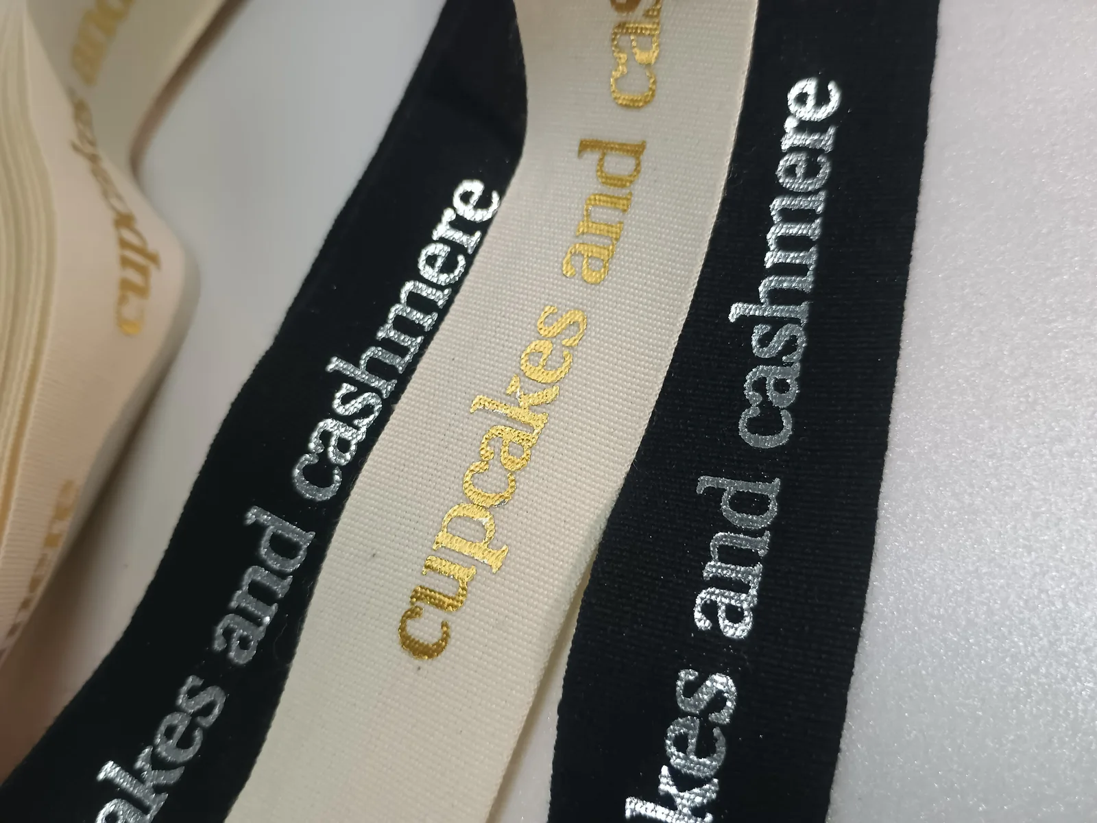 Black and ivory ribbons with contrasting metallic-coloured lettering