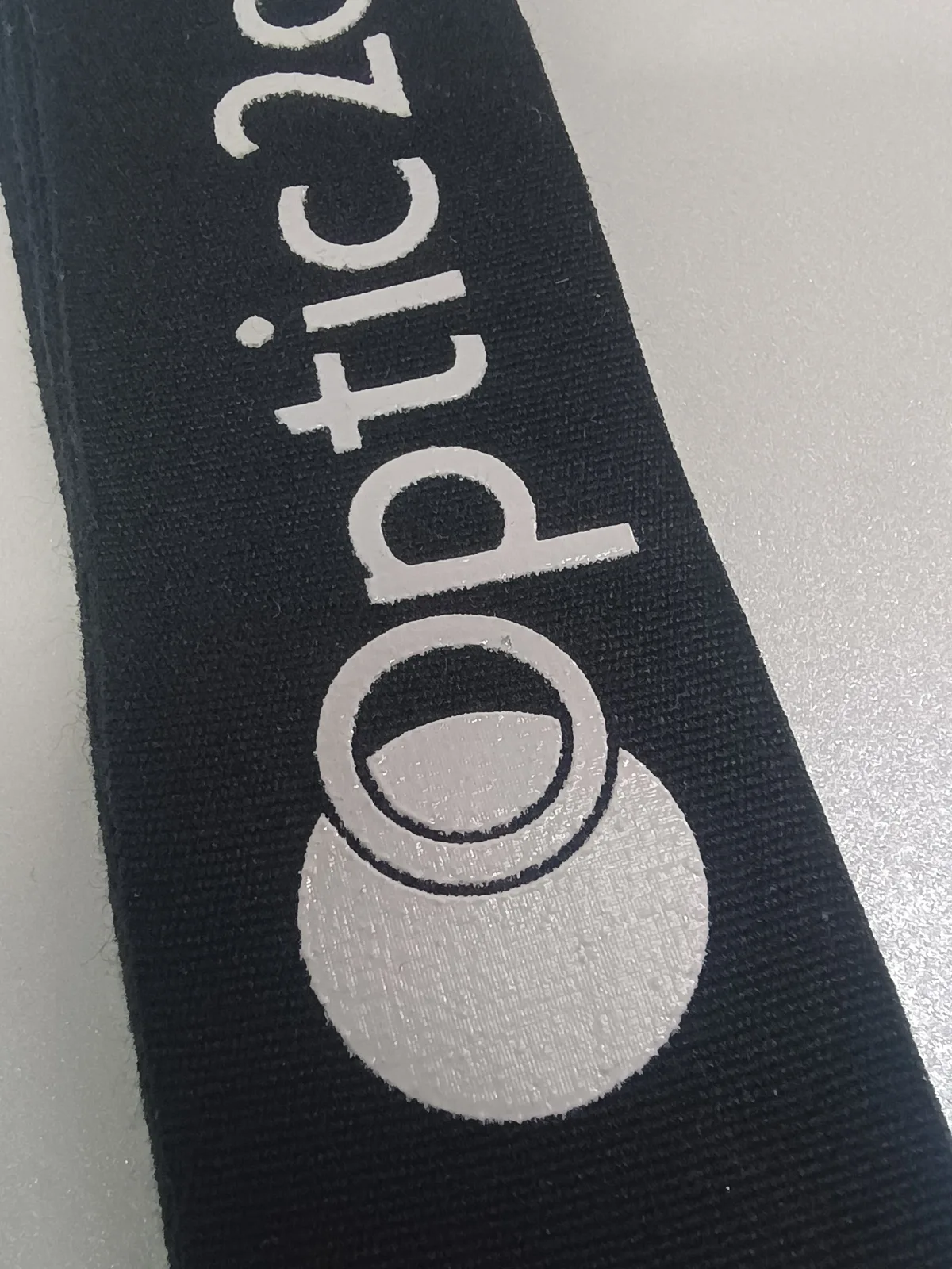 Silver-coloured lettering and graphic detail on black ribbon