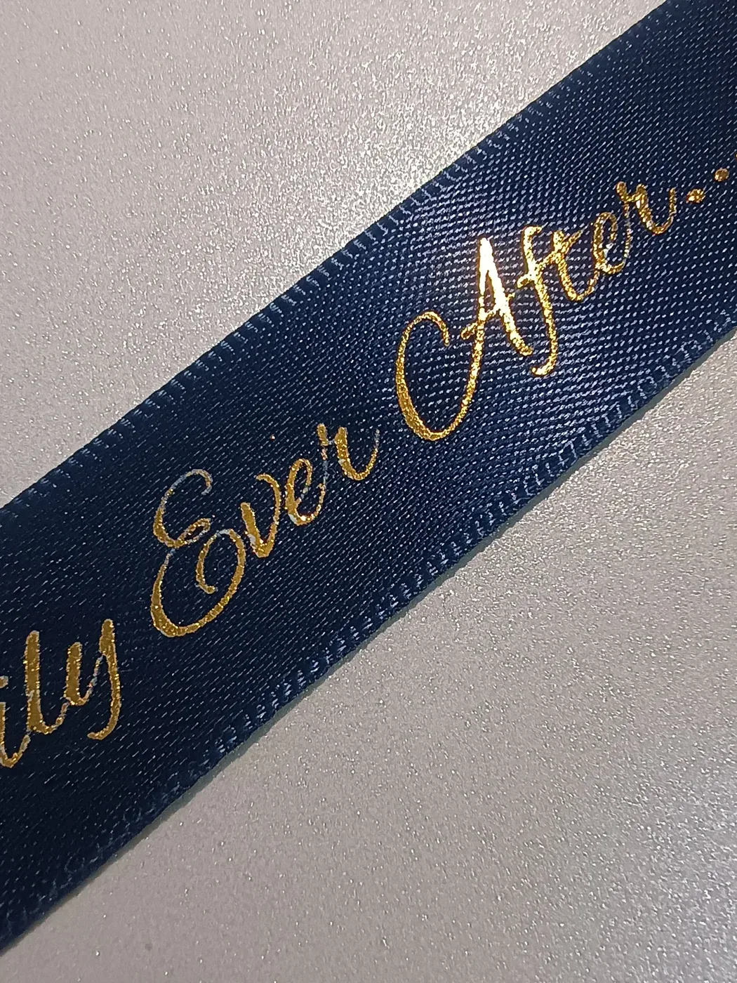 A close view of gold-coloured lettering on navy ribbon