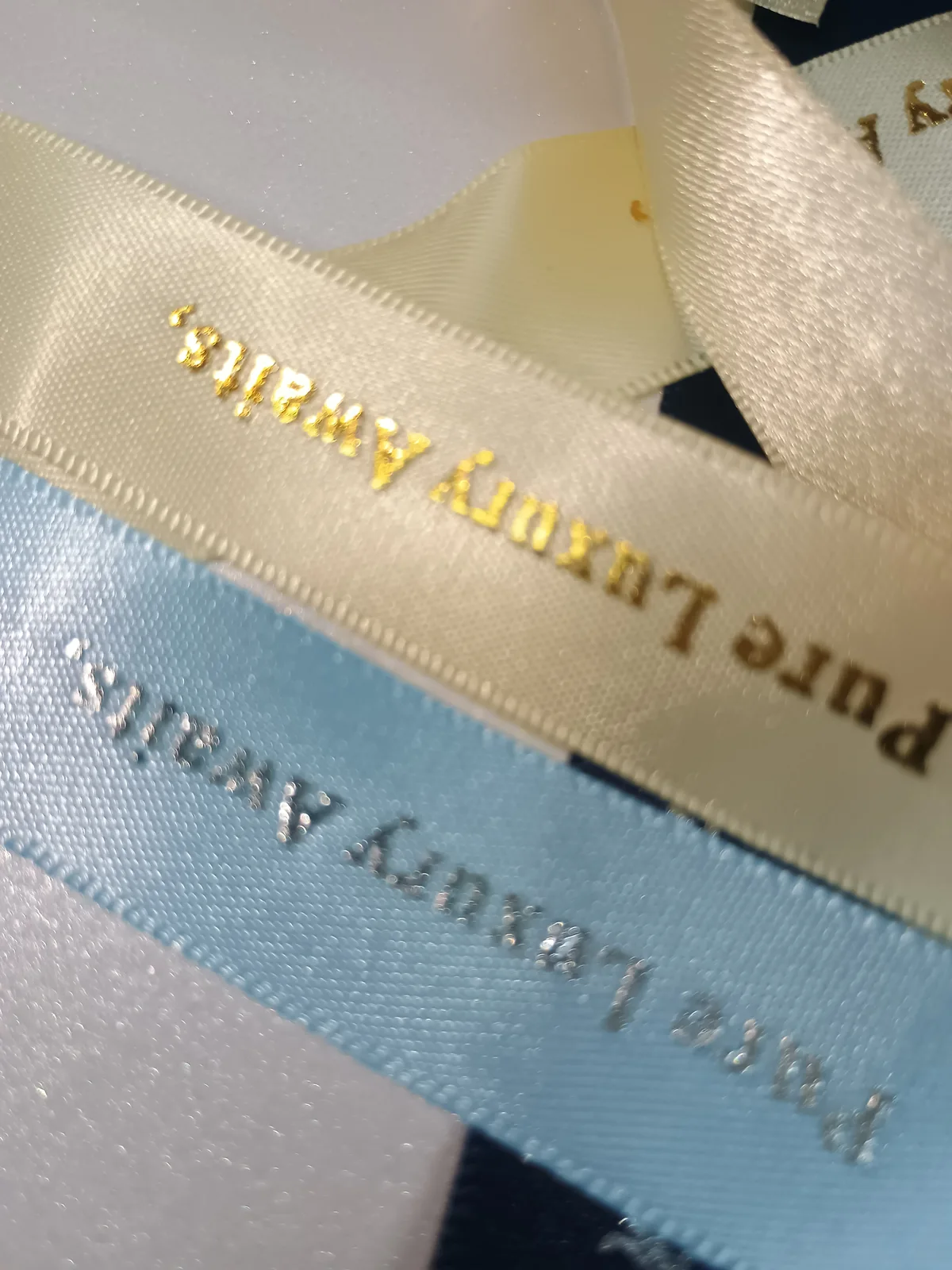 Cream and pale-blue ribbon with metallic-coloured lettering